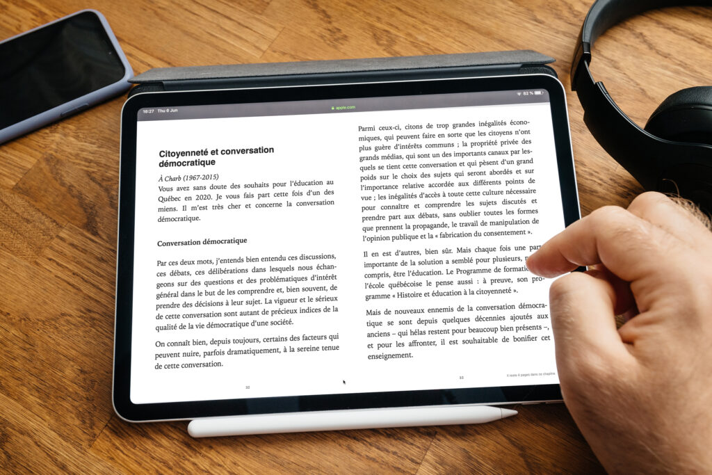 Image d'un livre numérique affiché sur tablette iPad. Incluant un téléphone et des écouteurs nous rappelant que les livres peuvent être lu par une voix de synthèse sur ces deux appareils.